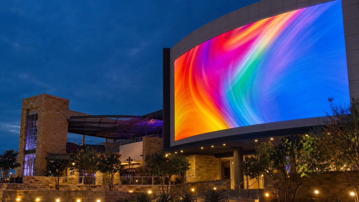 Outdoor LED video display on a commercial building at dusk